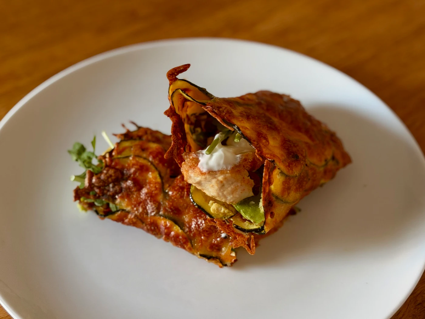 Rolled courgette and mozzarella wrap, filled with chicken, avocado, sun-dried tomato and rocket, sliced to show the filling